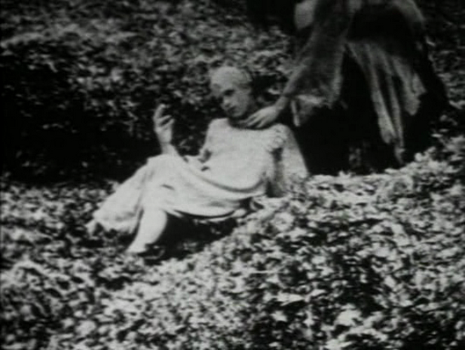 The 'Mother Earth' character reclining in leaves, being touched by a shadowy hand.